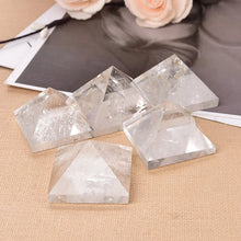 Crystal pyramids on a textured surface with flowers in the background
