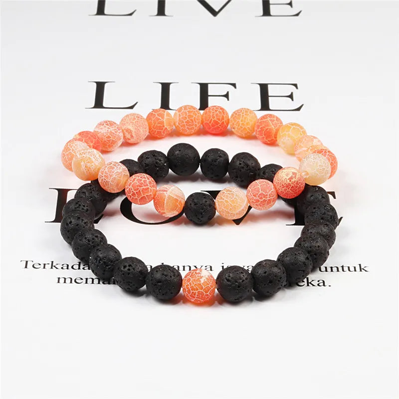 Two beaded bracelets with black and orange beads on a magazine background.