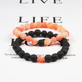 Two beaded bracelets with black and orange beads on a magazine background.