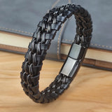 Black braided bracelet with a metallic clasp on a wooden surface