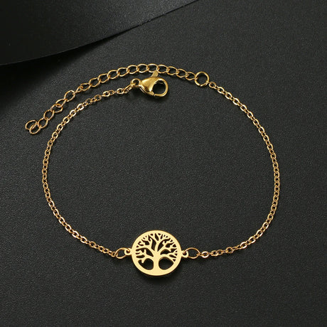 Gold bracelet with a tree of life charm on a black background