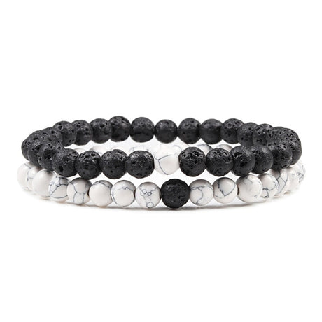 Set of three beaded bracelets with black and white stones on a white background