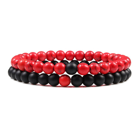 Stack of red and black beaded bracelets on a white background