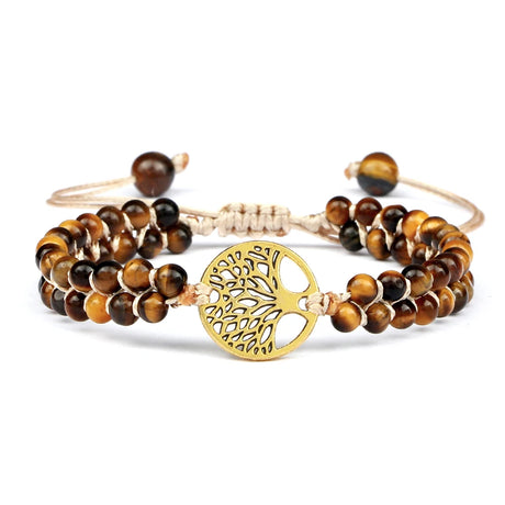 Set of beaded bracelets with a gold tree-of-life charm on a white background