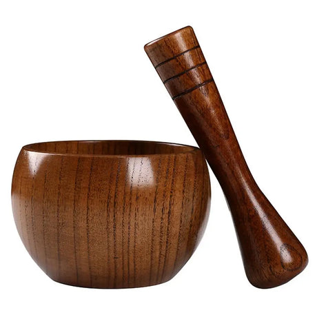 Wooden bowl and wooden mace on a white background