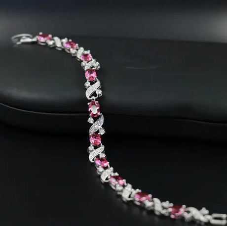 Silver bracelet with pink gemstones on a black background