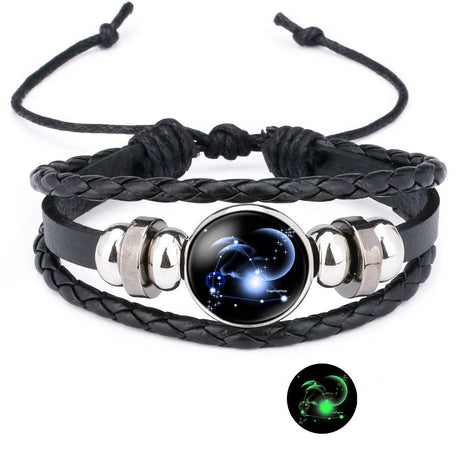 Black braided leather bracelet with silver accents and a glowing celestial design on a white background.