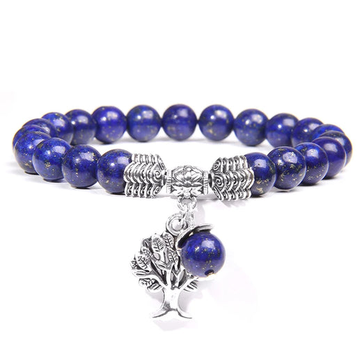 Blue beaded bracelet with silver tree charm on a white background