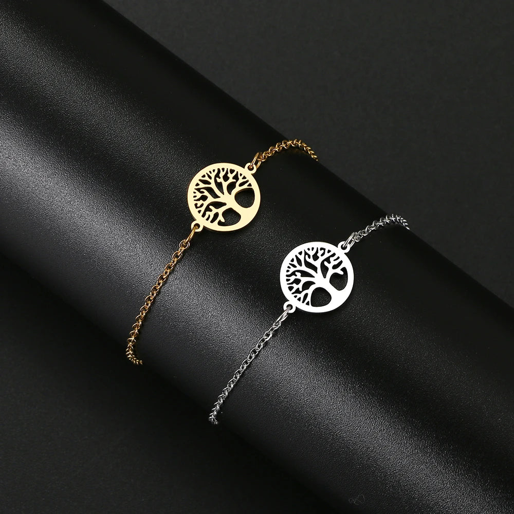 Gold and silver tree-of-life bracelets on a black fabric background