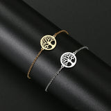 Gold and silver tree-of-life bracelets on a black fabric background