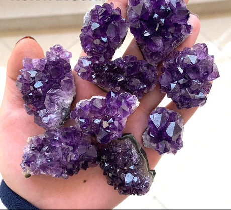 Hand holding purple amethyst crystals with 'RUNYANGSHI' branding.