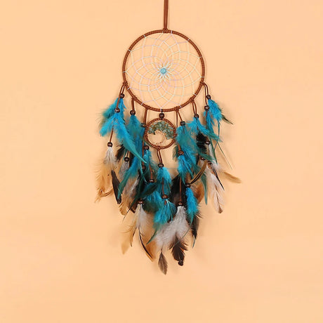 Dreamcatcher with blue feathers on a beige background