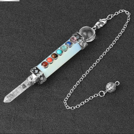 Crystal wand with colorful stones and chain on a dark background