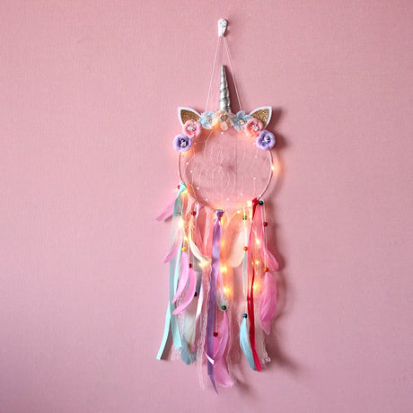 Unicorn-themed dreamcatcher with lights on a pink background
