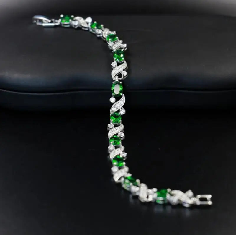 Bracelet with green and clear stones on a black surface