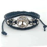 Black braided leather bracelet with silver tree of life charm on a white background