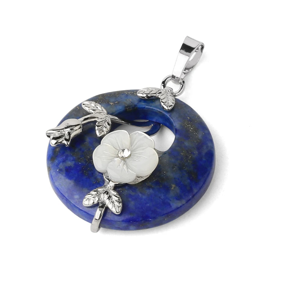 Jewelry pendant with blue stone and silver floral design on a white background