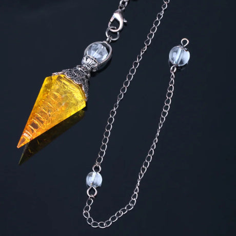 Jewelry with a yellow gemstone and silver chain on a dark background