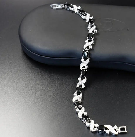 Silver bracelet with black stones on a dark surface