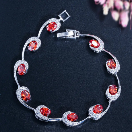 Silver bracelet with red gemstones on a dark background