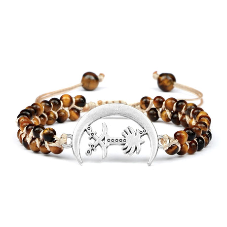 Bracelet with tiger eye beads and silver fish symbol charm on a white background