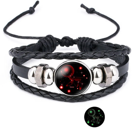 Black braided leather bracelet with a glowing red and black celestial design on a white background.