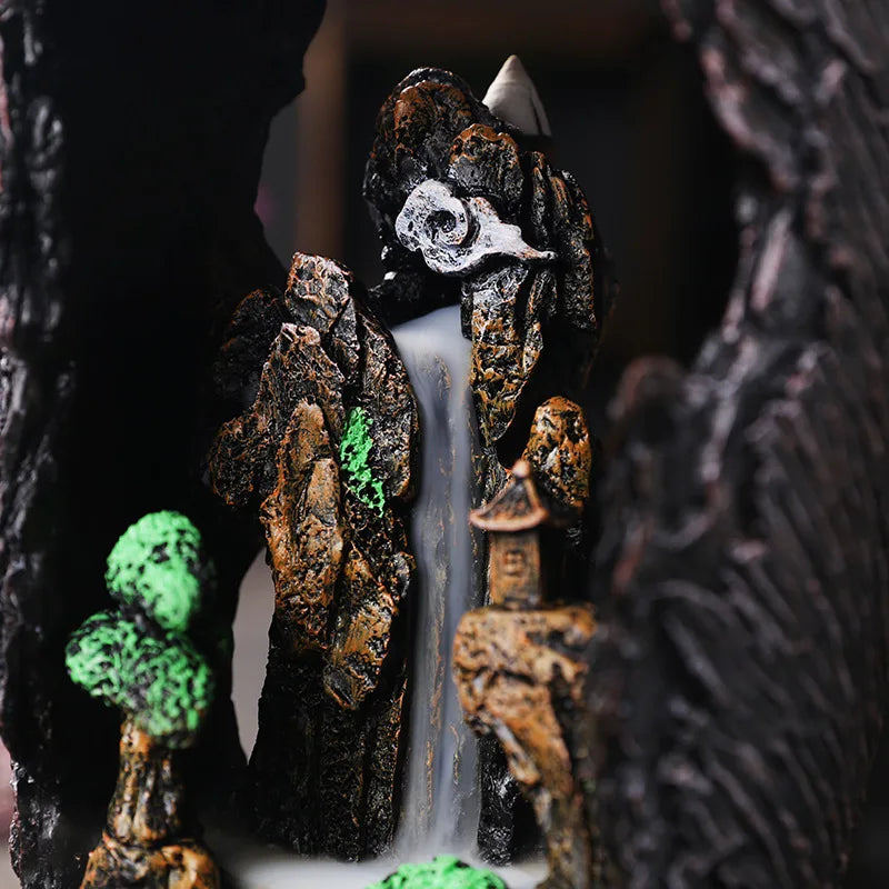 Decorative fountain with tree and house design against a dark background