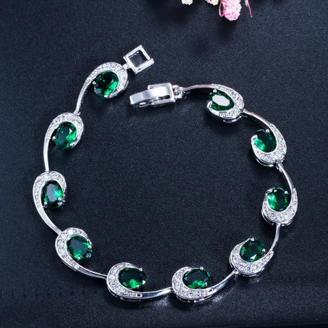 Silver bracelet with green gemstones on a dark background