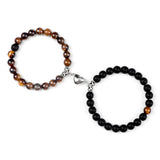 Two beaded bracelets, one with brown and black beads and the other with black beads, on a white background.