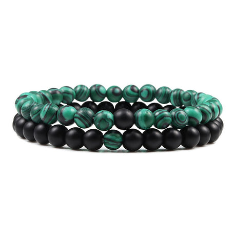 Set of two bracelets with green and black beads on a white background