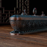 Decorative wooden box with intricate carvings on a wooden surface