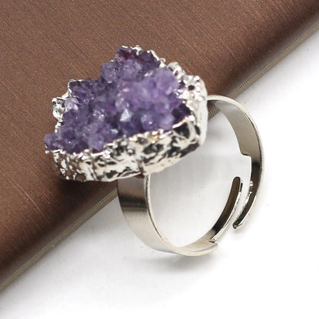 Silver ring with a purple crystal on a brown and white background