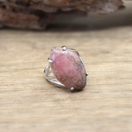 Ring with a pink stone on a wooden surface