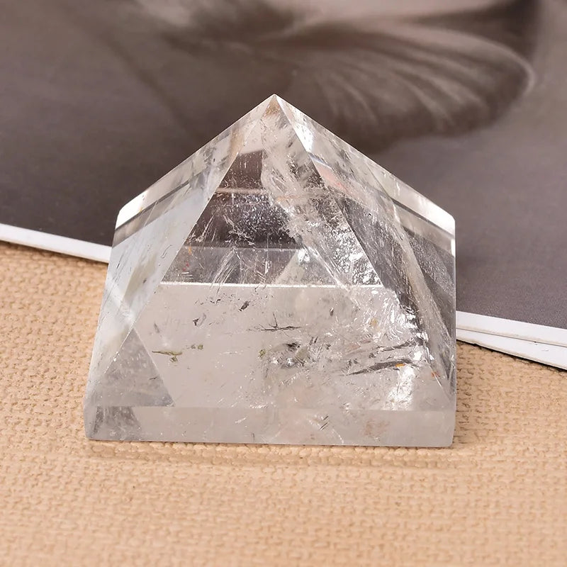 Clear crystal pyramid on a textured surface with a neutral background