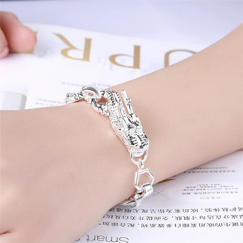 Silver bracelet on a wrist with a blurred magazine background