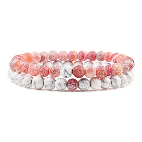 Set of three beaded bracelets with pink, white, and marbled patterns on a white background