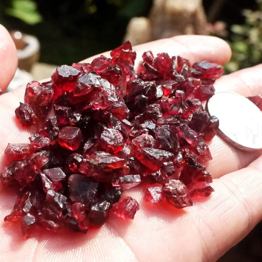 Red crystals held in a hand with a blurred background
