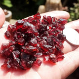 Red crystals held in a hand with a blurred background