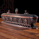 Decorative bronze censer with intricate designs on a wooden surface