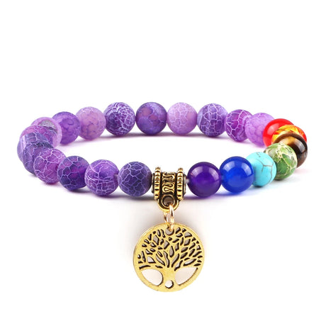 Multicolored beaded bracelet with a gold tree of life charm on a white background