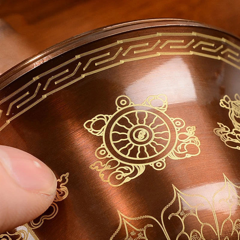 Close-up of a decorative object with intricate gold patterns on a wooden surface
