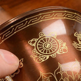 Close-up of a decorative object with intricate gold patterns on a wooden surface