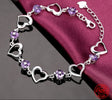 Silver bracelet with heart-shaped links and purple beads on a red fabric background, featuring the brand 'ZDADAN'.