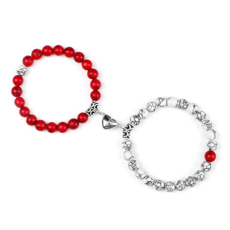 Two bracelets, one with red beads and the other with silver and red accents, on a white background.