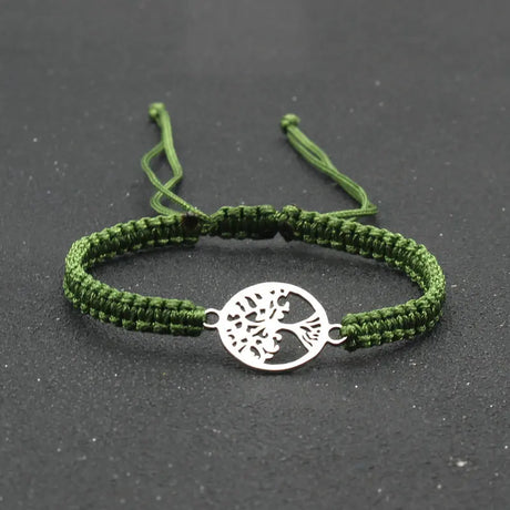 Green braided bracelet with a silver tree of life charm on a dark background