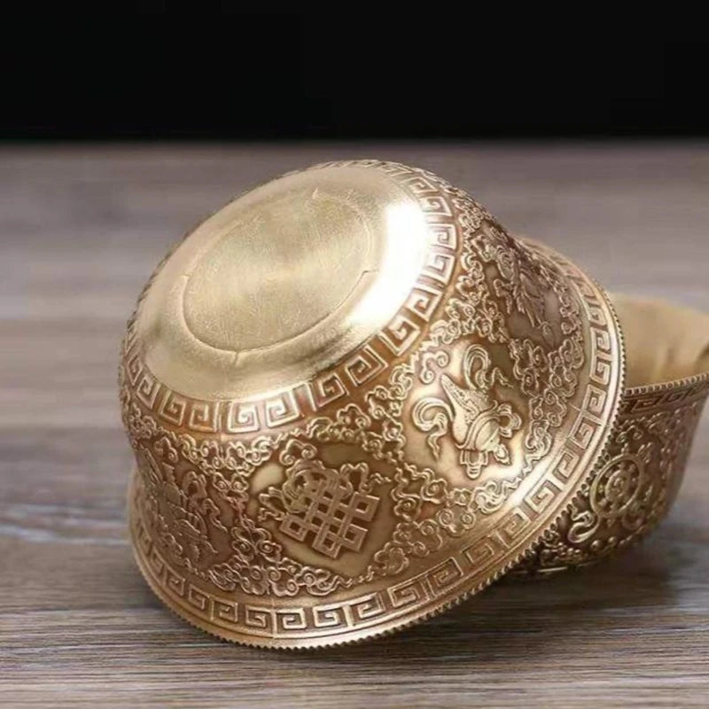 Decorative gold bowl with intricate patterns on a wooden surface