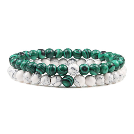 Set of three beaded bracelets with green and white stones on a white background
