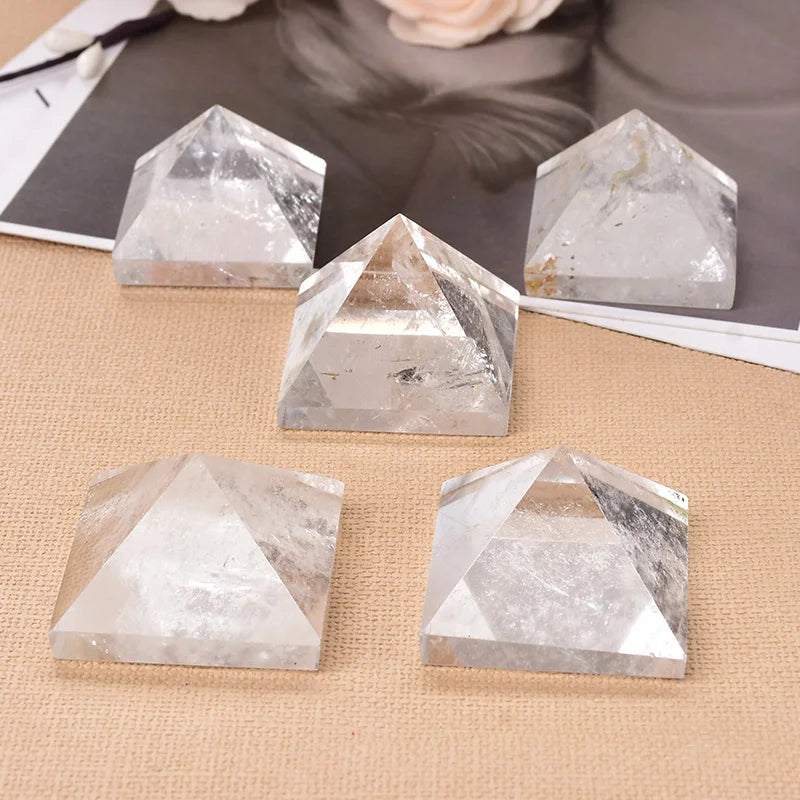 Five crystal pyramids on a textured surface with a blurred background