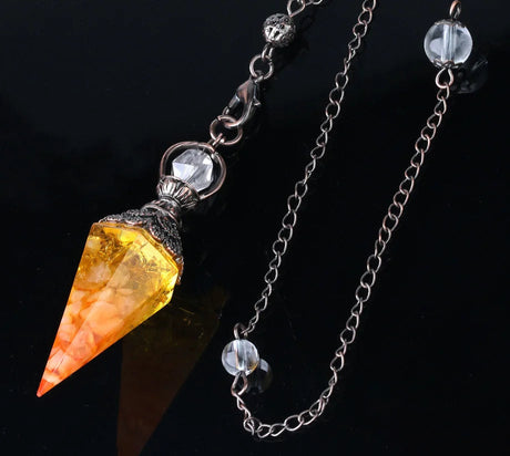 Crystal pendulum with chain on a dark background, featuring 'Cala Jewelry' logo.