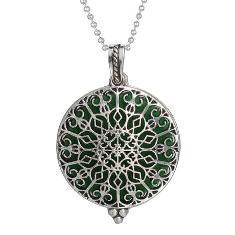 Silver pendant with green enameled design on a white background